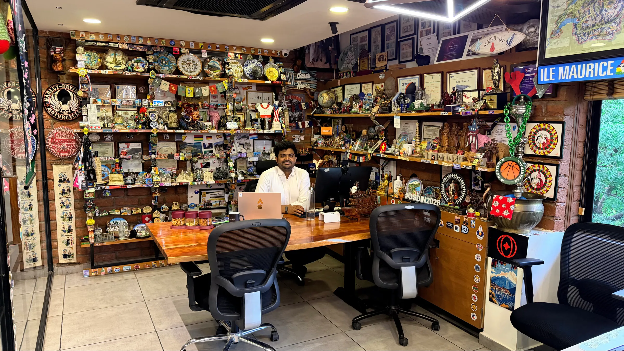 Vishal Rajpurohit's desk, its shelves covered with souvenirs, certificates and conference memorabilia collected across 35+ countries