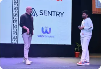 Vishal Rajpurohit on stage beside sponsor logos including Sentry and Webreinvent