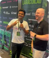 Vishal Rajpurohit holding a microphone beside a Laracon Australia backdrop