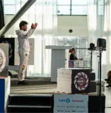 Vishal Rajpurohit gesturing while presenting near a Laravel-branded booth