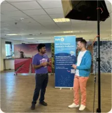 Vishal Rajpurohit in conversation beside a company banner in a meeting room