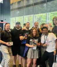 Vishal Rajpurohit in a group photo with conference attendees near a glass atrium