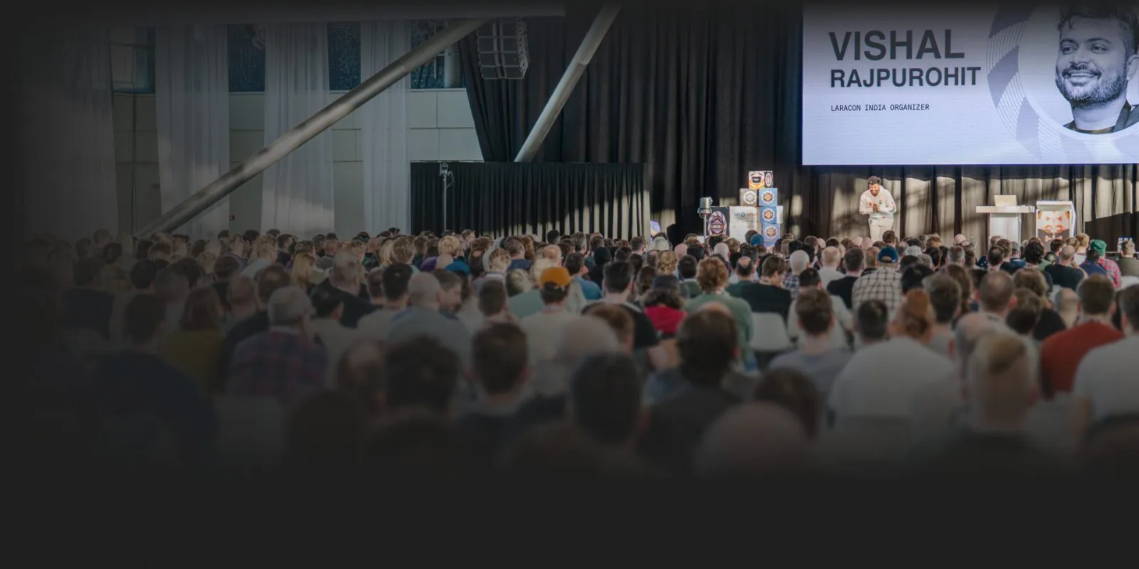 Vishal Rajpurohit speaking on stage to a large conference audience